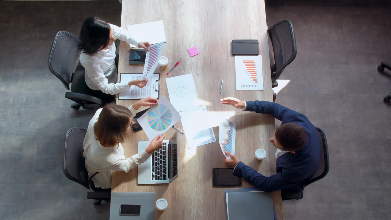 Colleagues gathered around a table of documents